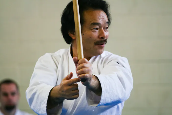 With the bokken.